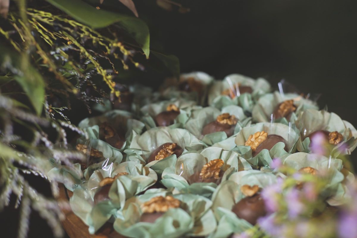 Doces em forminhas verdes entre flores do campo